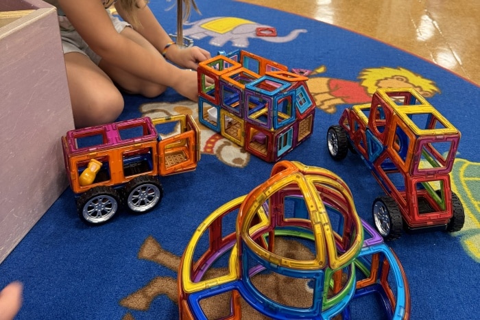 En la imagen se ve una niña jugando con imanes de construccion en Playville Osaka