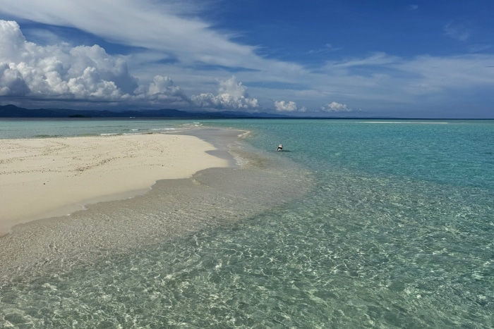 En la foto se ve a una niña en un banco de arena en Raja Ampat